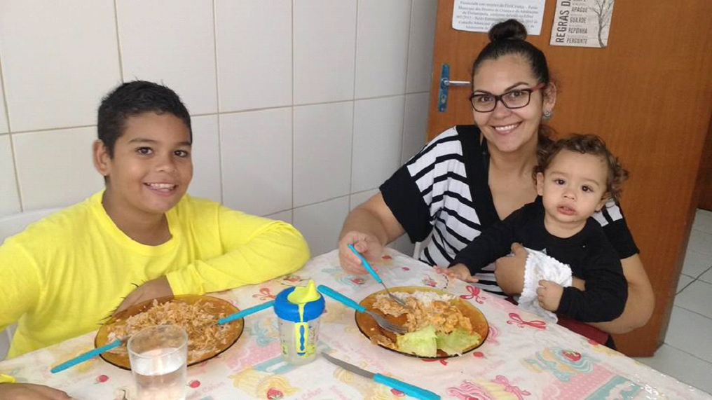 Criança, mulher e bebê comendo.